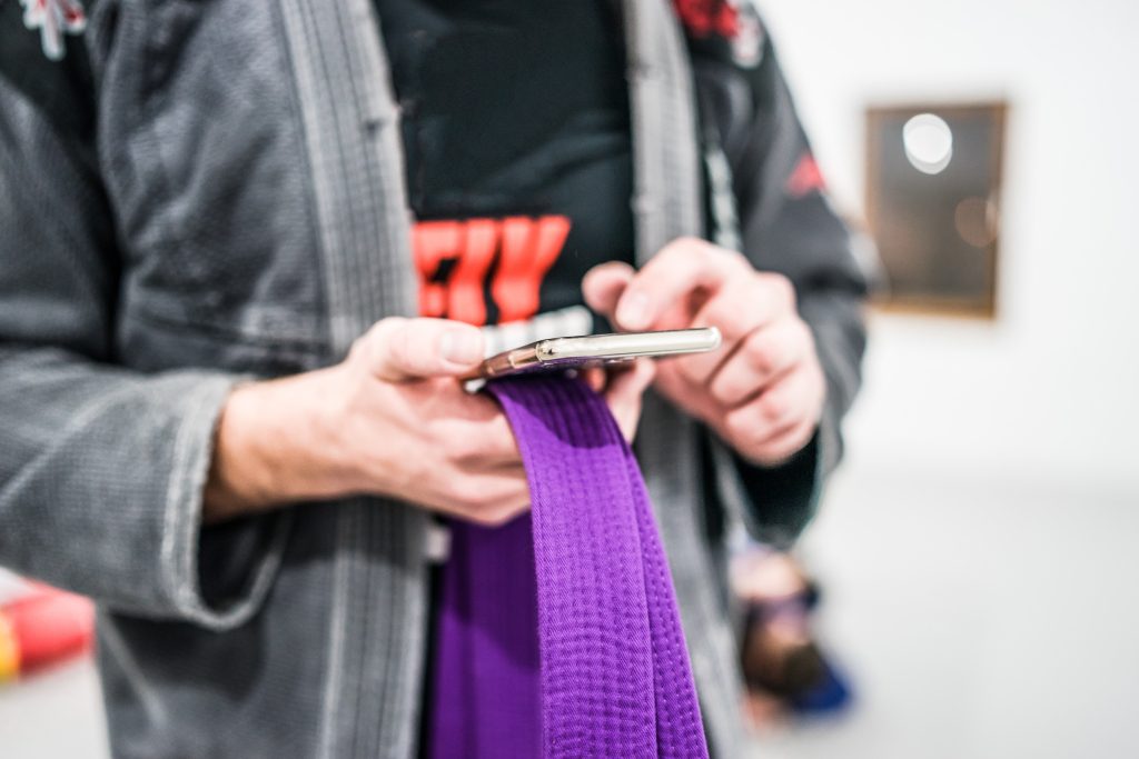 Brazilian jiu jitsu businesses owner receiving a new website lead notification on his phone from his lead generating website made by 97 display